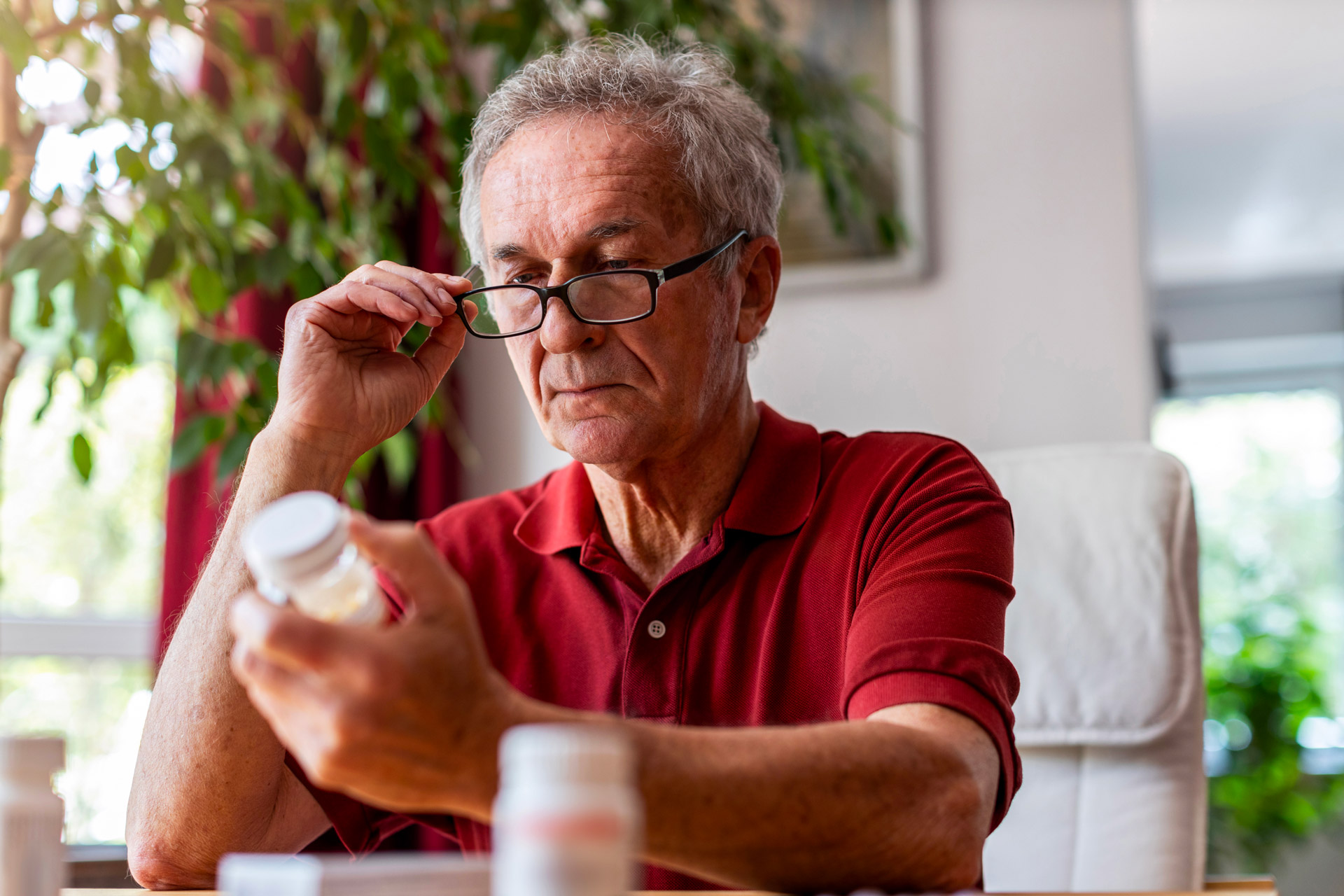 Homme lissant les instructions sur un contenant de médicament