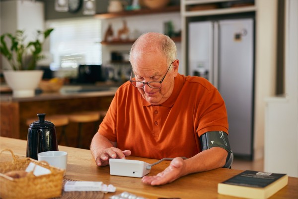 Un homme âgé qui utilise un machine pour calculer la pression